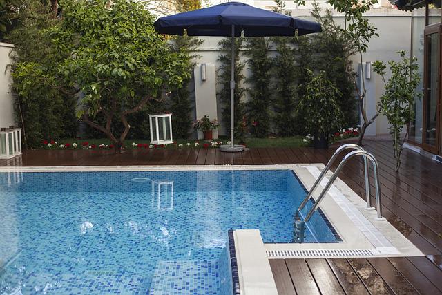 Luxurious backyard oasis featuring a freeform swimming pool, integrated spa, and natural rock waterfall, built by CPR Pools, Hawthorne builder
