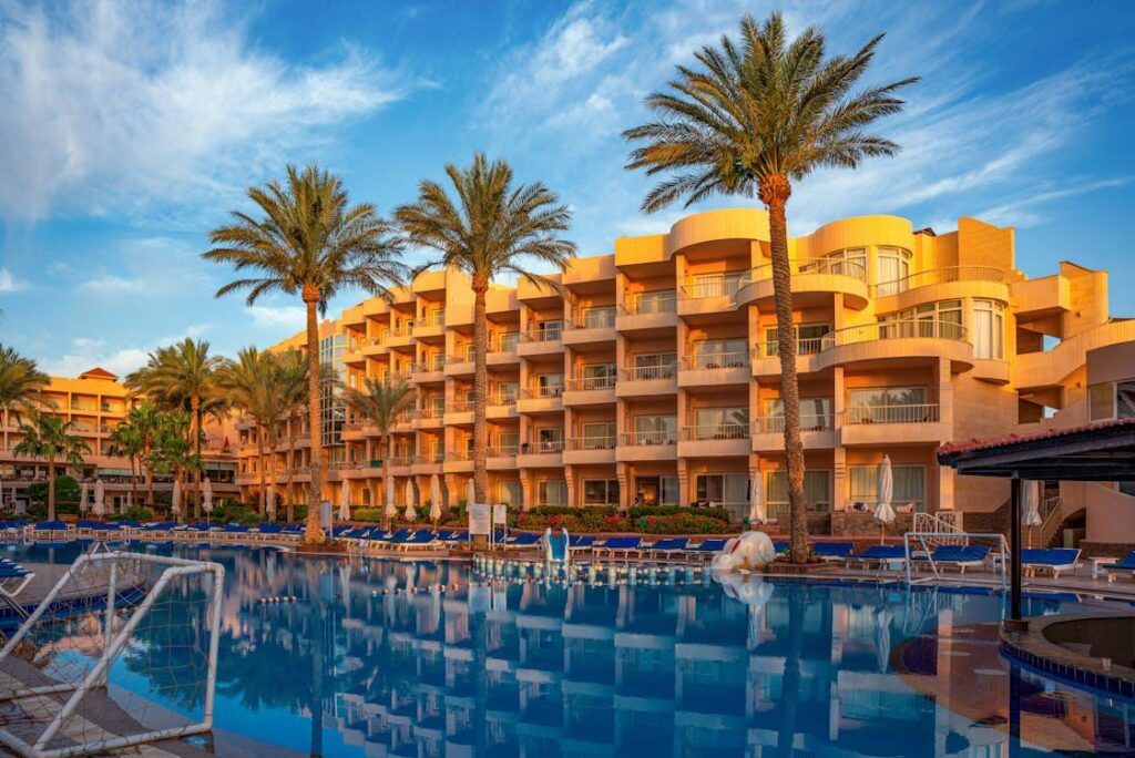 An apartment building with a swimming pool and palm trees