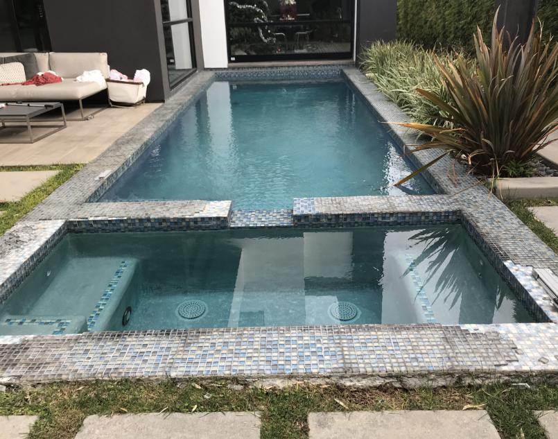 A stylish pool built into an elevated deck, overlooking a scenic landscape.

